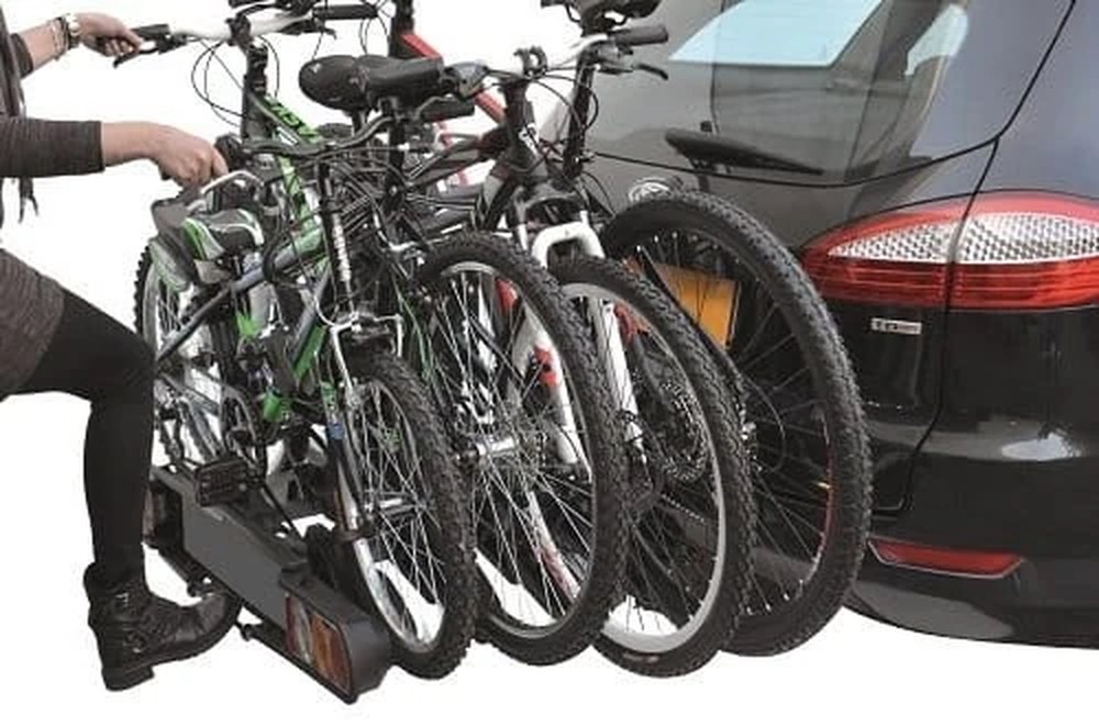 Peruzzo Pure Instinct COMO 4 z czterema rowerami zamontowany na haku samochodu, w pozycji uchylonej