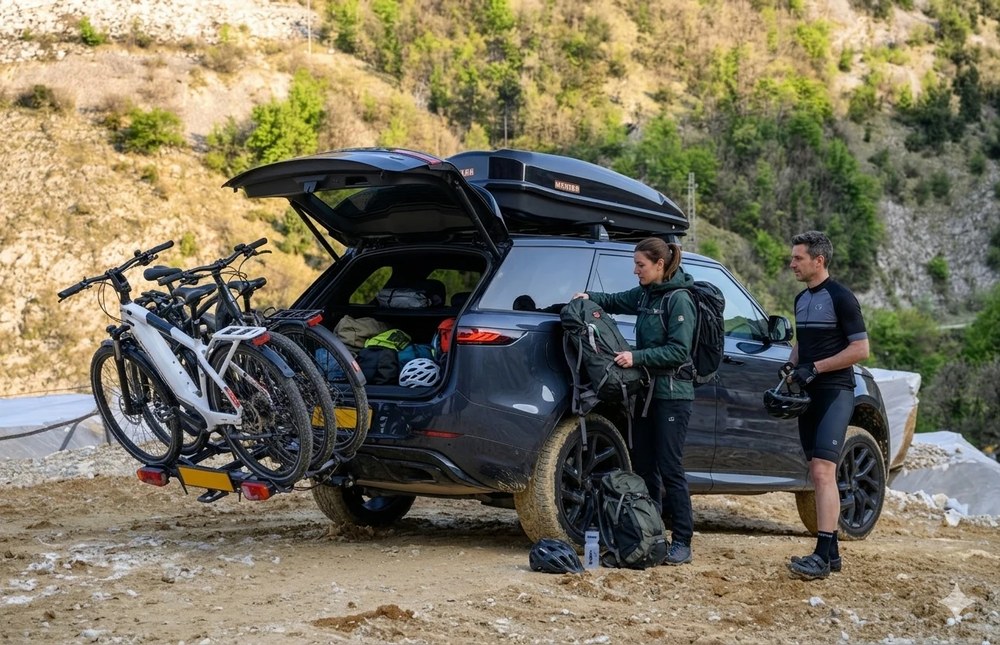 Dwoje rowerzystów przy SUV-ie z rowerami elektrycznymi na bagażniku MENABO ORBIT 3